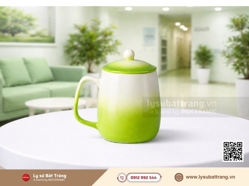 Ly sứ dáng bầu kết hợp quai vuông và nắp đậy men màu là dòng quà tặng trường học thuộc phân khúc cao cấp và nghệ thuật.